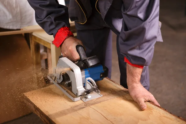 Manos carpintero trabajando con sierra circular — Foto de Stock