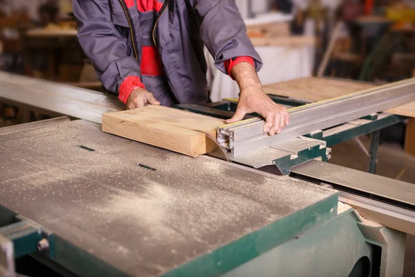 Carpentiere mani che lavora con una sega circolare — Foto Stock