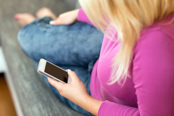 Jonge vrouw liggend op de Bank met mobiele telefoon — Stockfoto