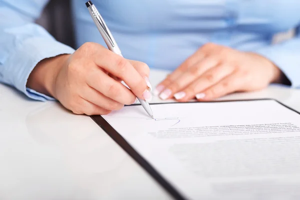 Mujer joven firma un contrato — Foto de Stock