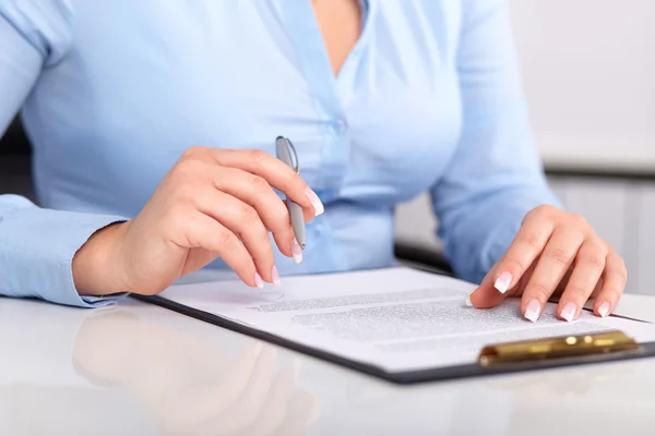 Jonge vrouw leest een ondertekend contract — Stockfoto