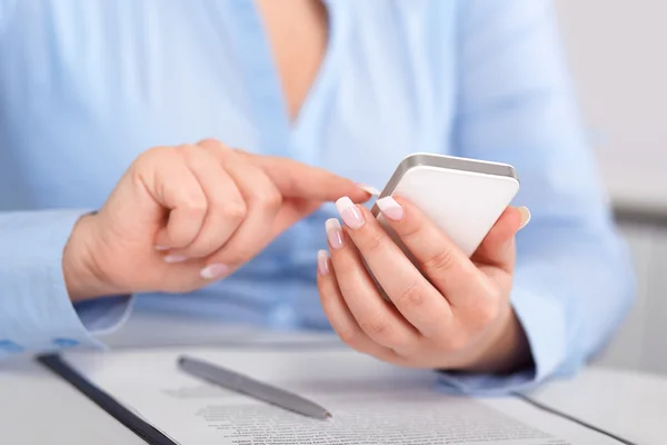 Giovane donna che lavora con un telefono cellulare sopra il contratto — Foto Stock