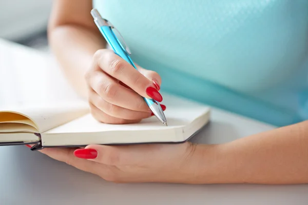 Jonge vrouw schrijft naar zwarte dagboek — Stockfoto