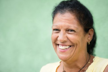 Portrait of happy old hispanic woman smiling at camera clipart