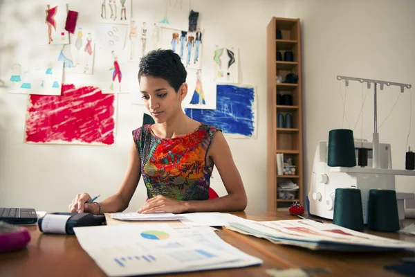 Mujer hispana haciendo presupuesto en taller de diseñador de moda — Foto de Stock