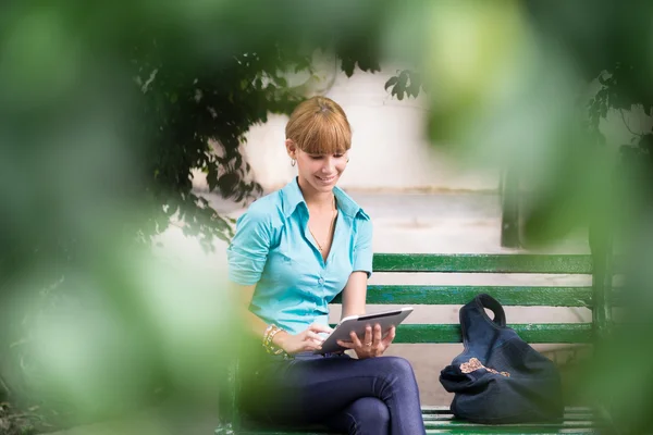 Spaanse vrouw met digitale tablet pc op Bank — Stockfoto