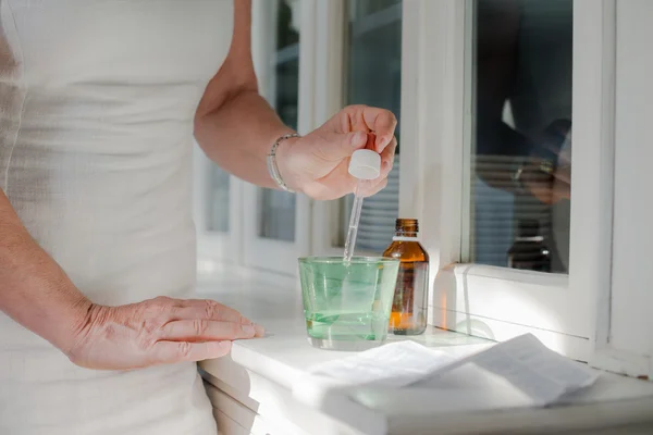 Health issues, old woman taking prescription drugs and drinking — Stock Photo, Image