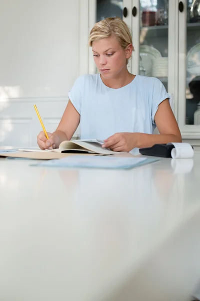 Junge Frau prüft Rechnungen und erledigt Haushalt zu Hause — Stockfoto