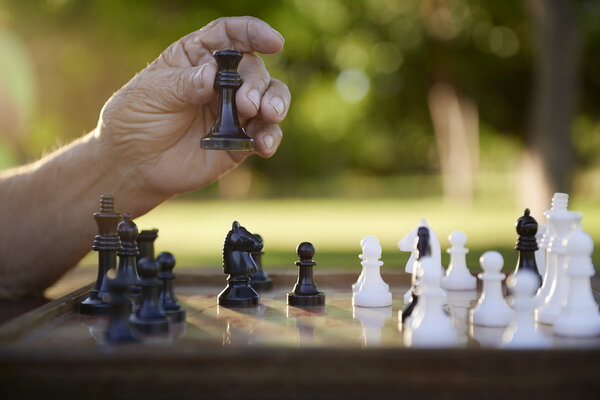 Active retired , senior man playing chess at park