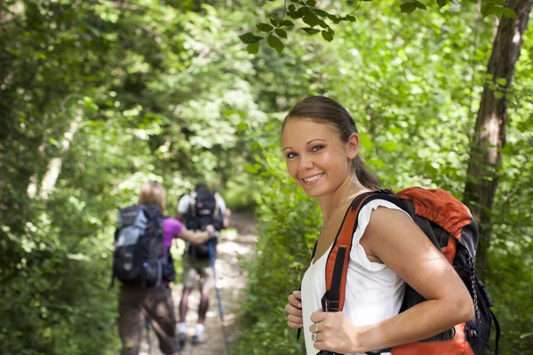 Com mochila fazendo trekking em madeira — Fotografia de Stock