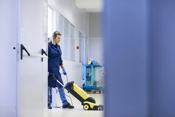 Women at workplace, professional female cleaner washing floor in — Stock Photo, Image