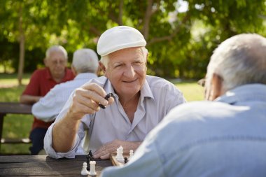 Active retired seniors, two old men playing chess at park clipart