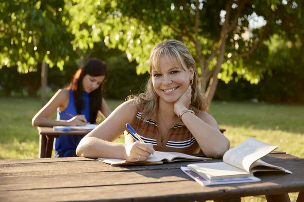 Junge Frauen lernen mit Lehrbuch für College-Prüfungen in der Schule — Stockfoto