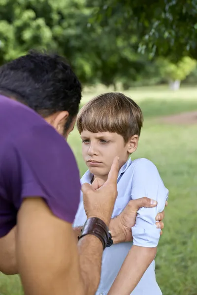 Elternschaft und Kindererziehung, wütender Mann beschimpft Jungen auf Augenhöhe — Stockfoto