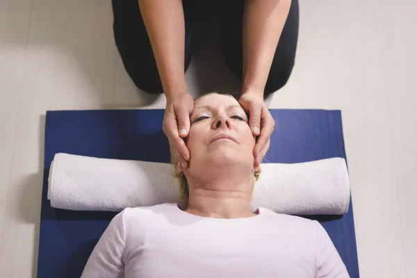 Jovem terapeuta fazendo terapia reiki para a mulher idosa — Fotografia de Stock