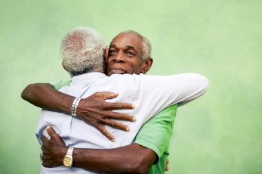 Old friends, two senior african american men meeting and hugging