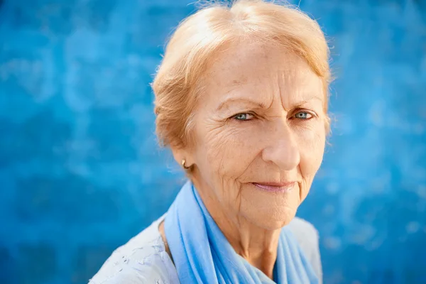 Gelukkig oude blonde vrouw glimlachen en kijken naar camera — Stockfoto