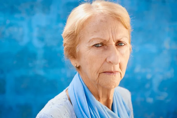 Trieste oude blonde vrouw kijken camera — Stockfoto