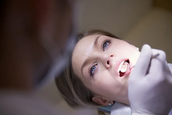 Νεαρή γυναίκα σε οδοντιατρείο με οδοντίατρο τον έλεγχο της υγιεινής των δοντιών — Φωτογραφία Αρχείου