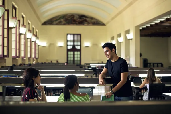 Grupo de estudantes felizes e amigos que estudam na biblioteca da escola — Fotografia de Stock