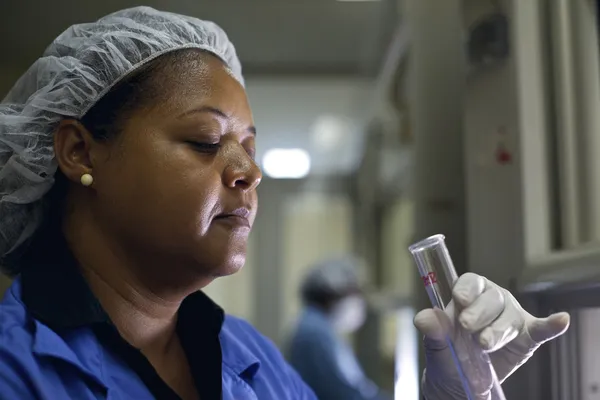 Vrouw die werkt in pharamaceutical lab met reageerbuisjes — Stockfoto