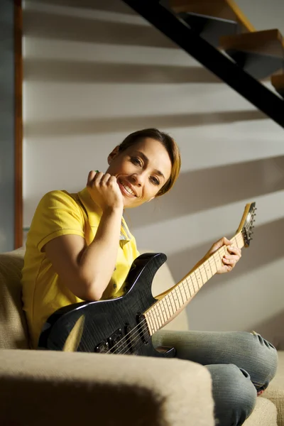 Porträt einer Frau, die zu Hause mit der E-Gitarre spielt — Stockfoto