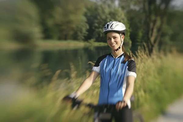 Junge Frau trainiert auf Mountainbike und radelt im Park — Stockfoto