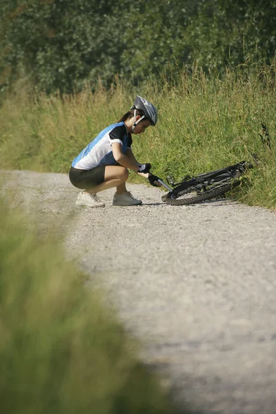 Junge Frau trainiert auf Mountainbike und radelt im Park — Stockfoto