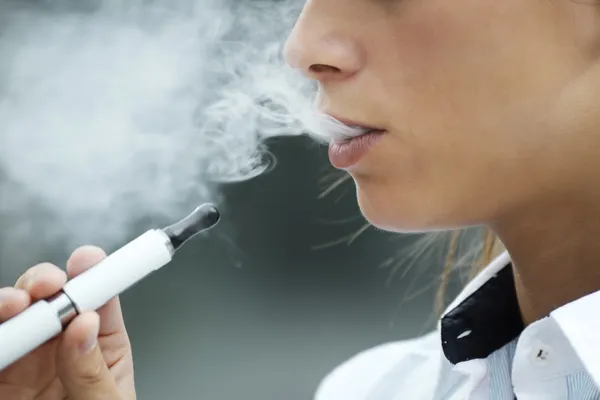 Крупный план женщины, курящей электронную сигарету на открытом воздухе — стоковое фото