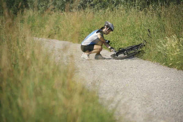 Jeune femme de formation sur le vélo de montagne et le vélo dans le parc — Photo
