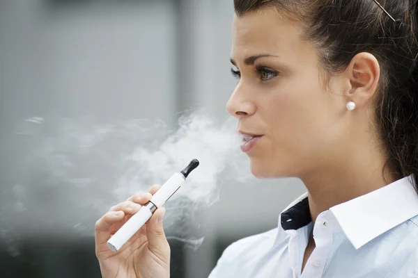 Young woman smoking electronic cigarette outdoor office building — Stock Photo, Image