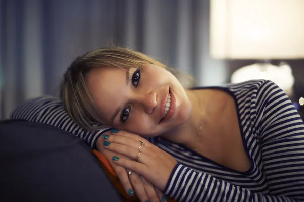 Hispanic woman relaxing on sofa and smiling — Stock Photo, Image