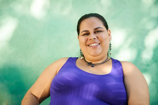 Портрет толстой женщины, смотрящей в камеру и улыбающейся — стоковое фото