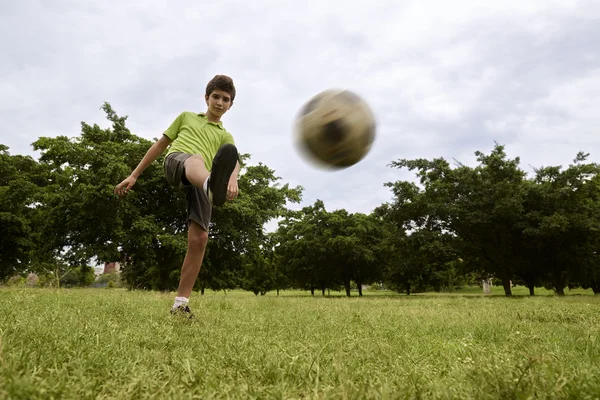 Bambino che gioca a calcio e calcio nel parco — Foto Stock