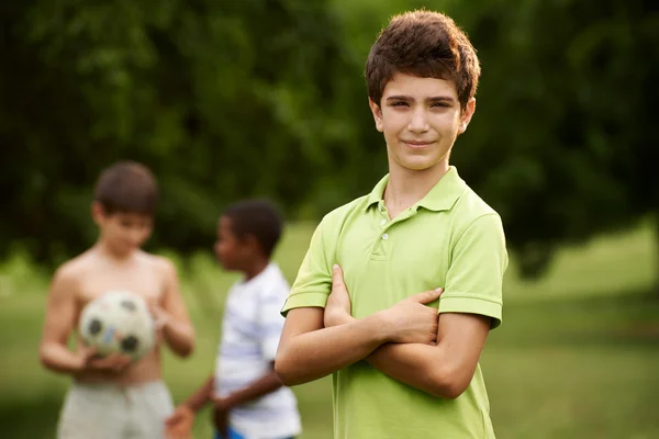Retrato de menino e amigos jogando futebol no parque — Fotografia de Stock