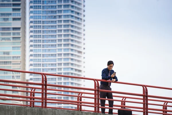 Retrato de asiático trabajador de oficina mensajes de texto en el teléfono móvil —  Fotos de Stock