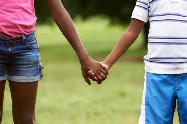 Niños enamorados negro chico y chica cogidos de la mano — Foto de Stock