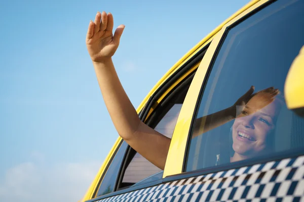 Mujer en taxi saludando la mano por la ventana del coche — Foto de Stock