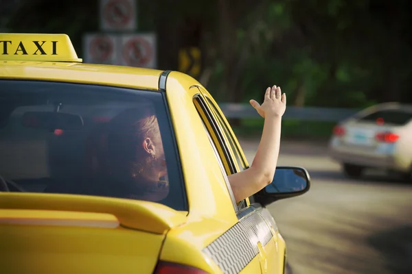 Mujer en taxi saludando la mano por la ventana del coche — Foto de Stock