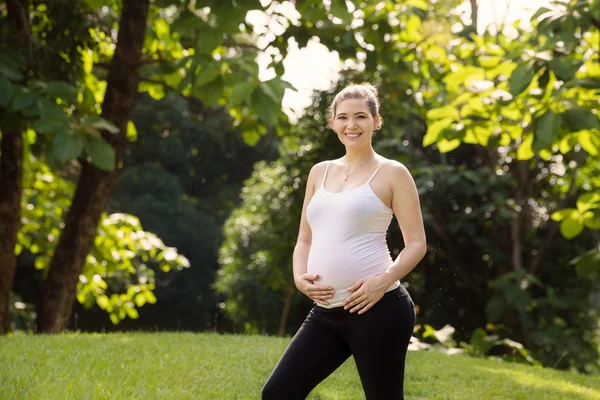 Portrait de femme enceinte heureuse et souriante dans le parc — Photo