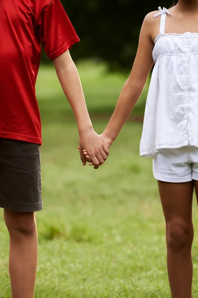 Niños enamorados niño y niña tomados de la mano — Foto de Stock