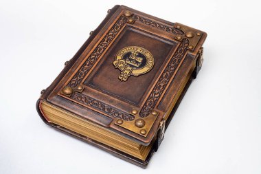 Üzerinde yaldızlı sembol bulunan antika kahverengi deri kitap izole bir şekilde yatıyordu.