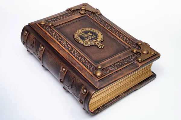 Üzerinde yaldızlı sembol bulunan antika kahverengi deri kitap izole bir şekilde yatıyordu.