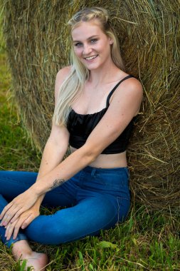 Sarışın bir çiftçinin kızı çiftlik ortamında poz veriyor.