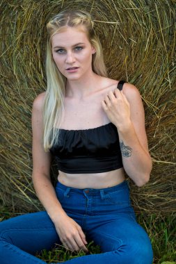 Sarışın bir çiftçinin kızı çiftlik ortamında poz veriyor.