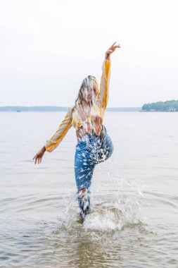 Muhteşem bir esmer model göl kenarındaki yaz havasının tadını çıkarıyor.