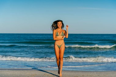 Güzel bir melez bikini modeli sahilde açık havanın tadını çıkarıyor.