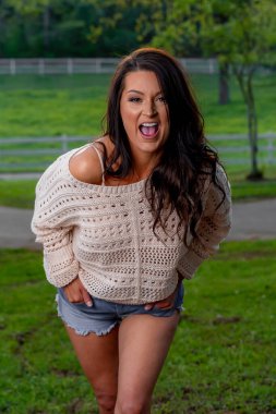 Muhteşem bir esmer model bahar havasının tadını çıkarırken dışarıda poz veriyor.