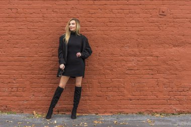 Güz havasının tadını çıkarırken dışarıda poz veren muhteşem bir sarışın model.