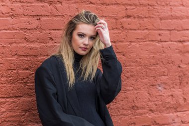 Güz havasının tadını çıkarırken dışarıda poz veren muhteşem bir sarışın model.